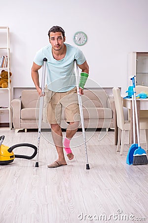Young injured man cleaning the house Stock Photo