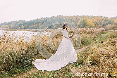 Young innocent bride posing outdoors. Cute charming girl with forest hills on background Stock Photo