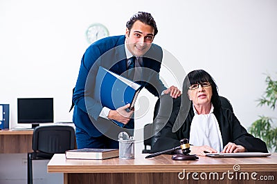 Young intern asking senior judge for advice Stock Photo