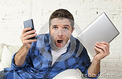 Young internet and technology addict man networking with mobile phone and digital tablet Stock Photo