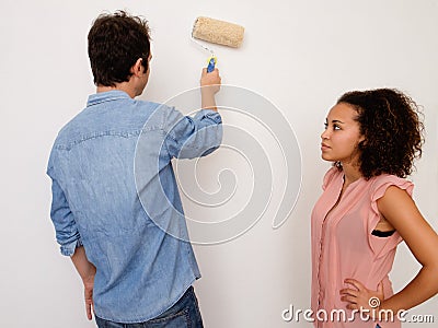 Young interracial couple painting the house wall together Stock Photo