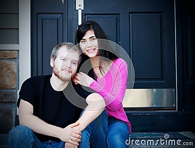 Young interracial couple sitting on front steps Stock Photo