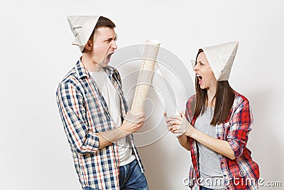 Young irritated woman, man in casual clothes holding wallpaper rolls and quarrelling. Couple isolated on white Stock Photo