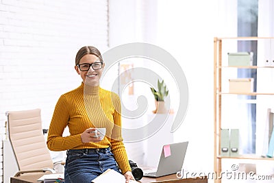 Young journalist with coffee at workplace in office Stock Photo