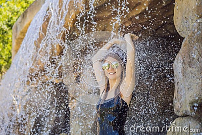 Young joyful woman under the water stream, pool, day spa, hot springs Stock Photo