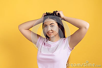 Young joyous girl ruffles long hair on head. Stock Photo