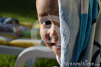 Young kid smiling to the camera after a nice bath in a swimming pool Stock Photo