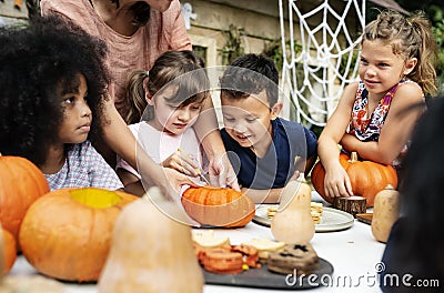 Young kids carving Halloween jack-o`-lanterns Stock Photo