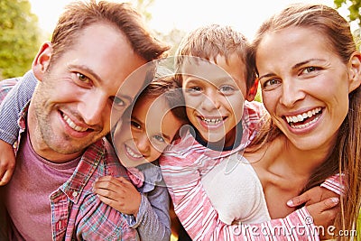 Young kids hugging parents outdoors, close up portrait Stock Photo