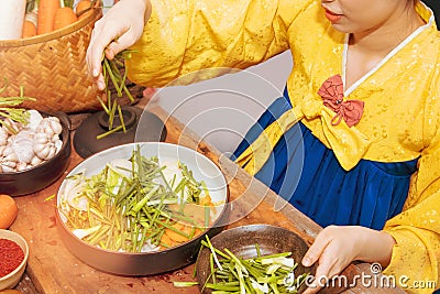 Young Korean women in golden hanbok cook traditional kimchi dishes using fresh and quality ingredients and ingredients : Pickled v Stock Photo