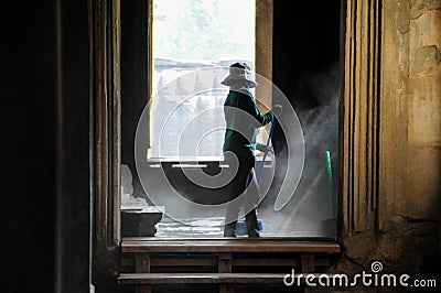 Young lady in cleaning floor in Angkor Archeological park. Monument of Cambodia - Siem Reap. Popular movie scenery. Editorial Stock Photo