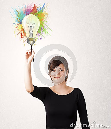 Young lady drawing a colorful light bulb with colorful splashes Stock Photo