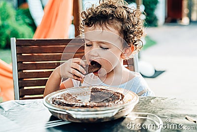 Young lady enjoys a chocolate cake for a snack Stock Photo