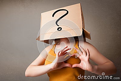 Young lady gesturing with a cardboard box on her head with quest Stock Photo