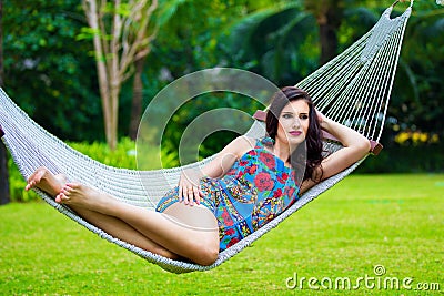 Young lady with long dark hair relaxing in hammock on the tropic Stock Photo