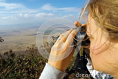 Young lady observing nature with binoculars Stock Photo