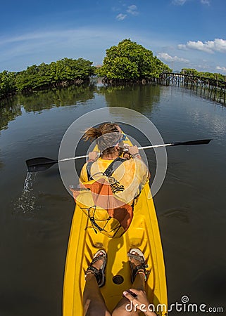 Young lady paddling hard the sea kayak with lots Stock Photo