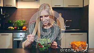 Young lady preferring salad to crisp. Stock Photo