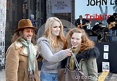 Young lady-singer and organizers of John Lennon 75th Anniversary Riga Festival Editorial Stock Photo