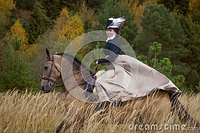 Young lady in 19th century dress riding a akhal teke horse Editorial Stock Photo