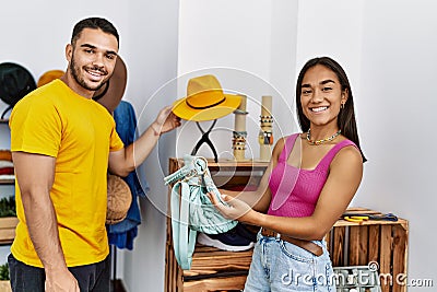 Young latin couple smiling happy choosing handbag at clothing store Stock Photo