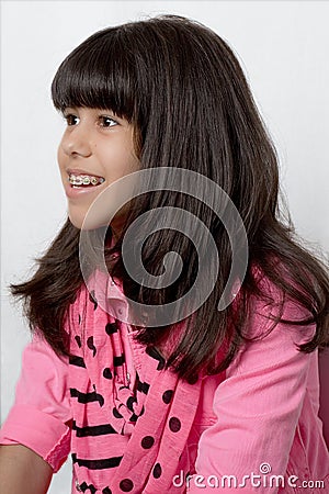 Young Latin Girl With Silky Hair & Colored Braces Stock Photo