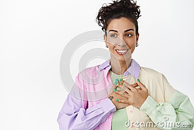 Young lesbian woman holding hand on heart, smiling happy and looking away at logo, being uplifted, pride and lgbtq Stock Photo