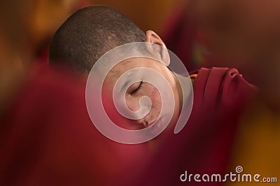 Young little child meditating with closed eyes at the regular puja. Editorial Stock Photo