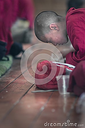 Young little child meditating / dreaming with open eyes at the regular puja from Leh village. Ladakh Editorial Stock Photo
