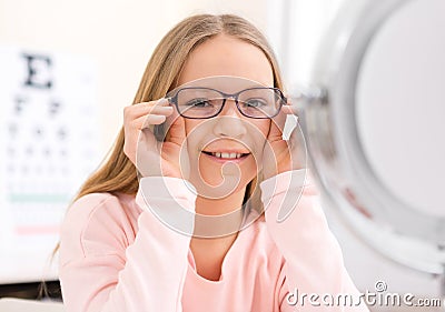 Young little girl trying glasses at the optician Stock Photo