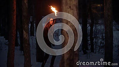 Young lost pretty woman with torch walking in the night forest Stock Photo