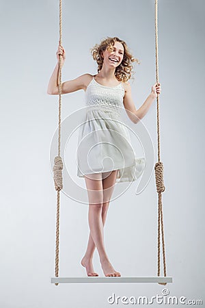 Young loughing bare-footed girl on swing Stock Photo