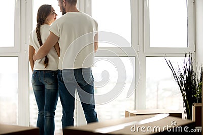 Young couple embracing in new apartment with packed belongings Stock Photo