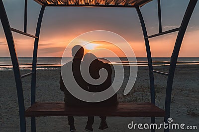 Young loving couple enjoying the sunset on the sea in autumn. Stock Photo