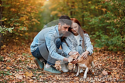 Young loving couple has found a stray dog. they are making friend with it Stock Photo