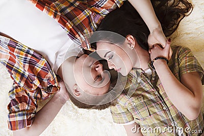 Young, loving couple, kiss each other, cover their lips with a candy in the form of a heart Stock Photo