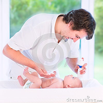 Young loving father changing diaper of his newborn baby son Stock Photo