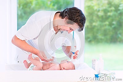 Young loving father changing diaper of newborn son Stock Photo