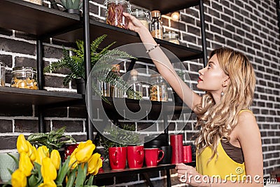 Young loving wife taking some spices while cooking dinner for her man Stock Photo