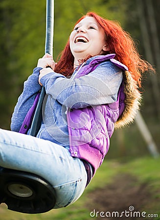 Young lucky girl is laughing while swinging Stock Photo