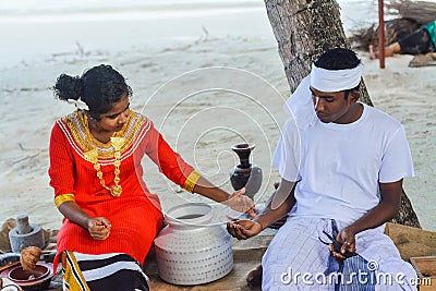 Young maldivian couple dressed in national clothes cooking food Editorial Stock Photo