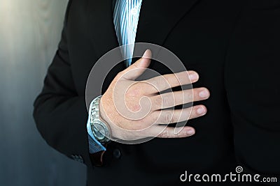 Young male business man holding his chest with pain Stock Photo