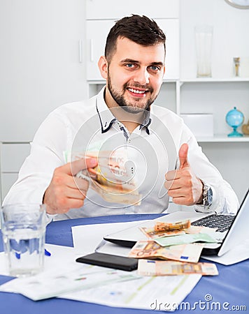 Young male businessman earning money easily online in Internet Stock Photo