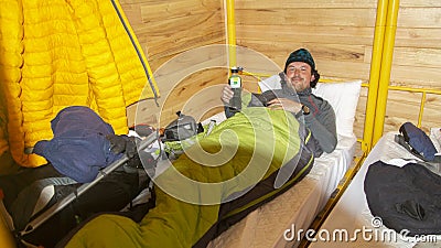 Young male climber resting on a bunk inside a mountain refuge Stock Photo