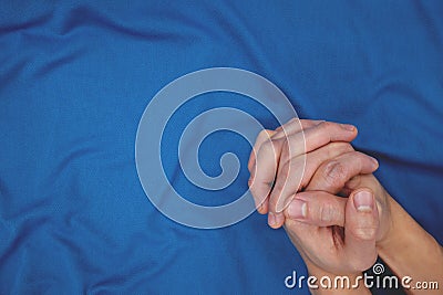 Young male closed hands praying top view in dark blue background. Stock Photo