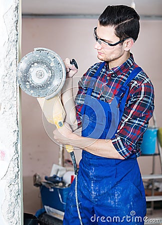 Male contractor using professional angle grinder Stock Photo