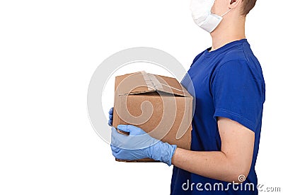 Young male courier in a medical mask and rubber gloves holding a box on a white background. Social concept. Helping the poor. Stock Photo