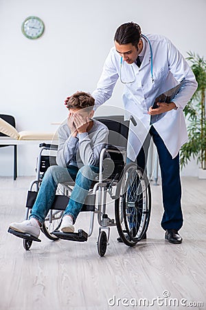 Young male doctor pediatrist and boy in wheel-chair Stock Photo