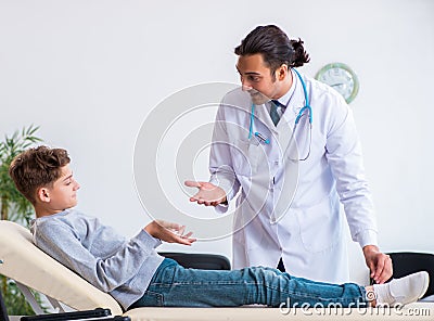Young male doctor pediatrist and boy in wheel-chair Stock Photo