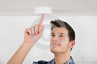 Male Electrician Testing Smoke Detector Stock Photo